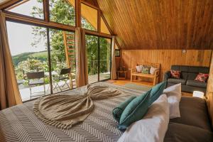 蒙泰韦尔德哥斯达黎加Tityra Lodge的一间带床的卧室，配有大窗户 更多129张照片