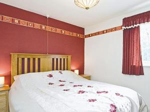 a bedroom with a large bed with red walls at Garburn View in Kentmere