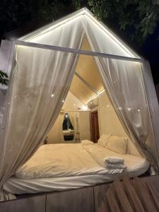 a bed with a canopy in a room at Retro Khe Sanh in Lao Bao