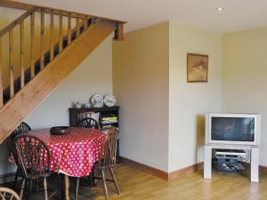a dining room with a table and a television at Wykham in Nettleton