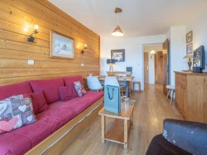 - un salon avec un canapé rouge et des murs en bois dans l'établissement Appartement au centre de la station avec balcon dans chalet, animaux acceptés - FR-1-645-45, à Huez