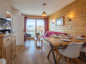 un salon avec une table et un canapé dans l'établissement Appartement au centre de la station avec balcon dans chalet, animaux acceptés - FR-1-645-45, à Huez