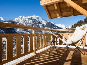 eine Terrasse mit einem Stuhl und Blick auf einen Berg in der Unterkunft Chalet Luxueux 10 Pers. à Serre Chevalier - Terrasse, Local à Ski, Navette Gratuite - FR-1-762-18 in La Salle Les Alpes + 4 Fotos