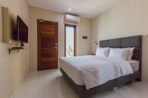 a bedroom with a large bed and a television at Victoria Villa Seminyak in Seminyak