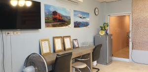a room with a desk with chairs and a flat screen tv at Moon Travel Phangan in Ban Nua