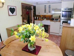 ボウネス・オン・ウィンダミアにあるRustic Cottageの台所のテーブル上の黄花瓶