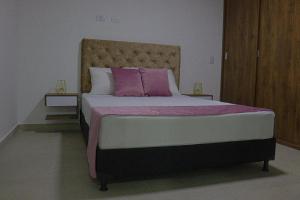 a bedroom with a bed with purple and white pillows at VIVA ALCALA in Envigado