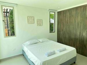 a bedroom with a bed with two towels on it at Hermosa Casa Campestre Con Piscina y Bar 