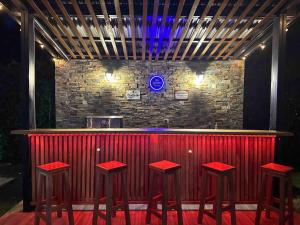 um bar com bancos vermelhos em frente a uma parede de tijolos em Hermosa Casa Campestre Con Piscina y Bar 