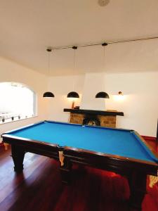 a blue pool table in a room with a fireplace at Youse Hostel in São Paulo