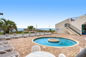 默特爾海灘的住宿－Ocean Park Resort 1222，一个带椅子的庭院和一个背景为大海的游泳池