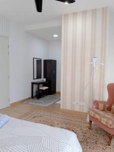 a bedroom with a bed and a couch and a television at Pinevalley Homestay Putrajaya Presint 12 in Putrajaya