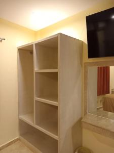 een grijze boekenplank in een kamer met een tv bij Hotel Parador del Rey in Temixco