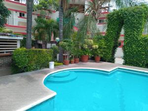 a large blue swimming pool in front of a building at Hotel Parador del Rey in Temixco