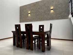een eettafel en stoelen met verlichting aan de muur bij Bolgoda Lake Villa in Moratuwa
