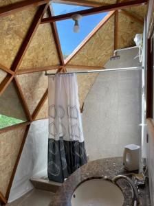 a bathroom with a sink and a shower curtain at Treff Lodge Hotel in Oxapampa