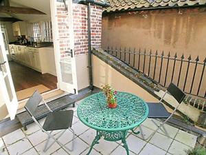 a table and chairs on a patio with a table and a plant at Crown And Anchor in Wells next the Sea