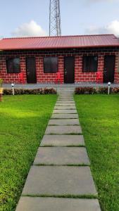 a walkway leading to a red brick building at DANDELI CROCODILE EDGE HOME STAY in Dandeli