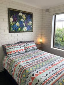 a bedroom with a bed and a painting on the wall at Serene Nature Retreat in Rhyll
