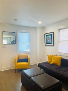 ein Wohnzimmer mit einem Sofa und einem gelben Stuhl in der Unterkunft Quaint 3/2.5 home in Fort Dupont in Washington