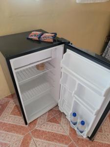 a small white refrigerator with its door open at Chelox Panama Airport in Cabuya
