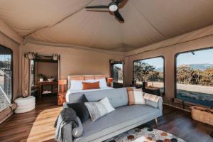 a bedroom in a safari tent with a bed and windows at Wildnest Farmstay in Capertee