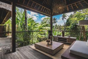 a living room with a view of the jungle at Luwak Estate in Ubud