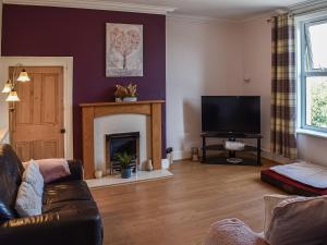 a living room with a couch and a fireplace at Rhiw Bank Apartment in Colwyn Bay