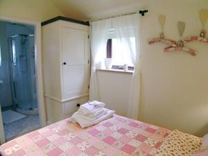 a bedroom with a bed and a shower and a bathroom at Owl Cotes Cottage in Cowling