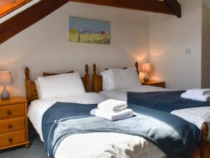 een slaapkamer met 2 bedden en handdoeken bij Golden Meadows - Uk12272 in Mevagissey