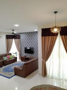 ein Wohnzimmer mit einem Sofa und einem TV in der Unterkunft Juniper Homestay Putrajaya Presint 11 in Putrajaya