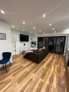 a large living room with a couch and a television at Holiday Home, Sleep 10 in London in South Norwood