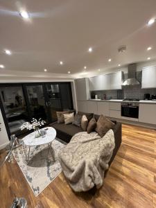 uma sala de estar com um sofá e uma mesa em Holiday Home, Sleep 10 in London em South Norwood
