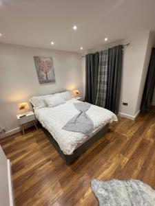 a bedroom with a bed and a wooden floor at Holiday Home, Sleep 10 in London in South Norwood