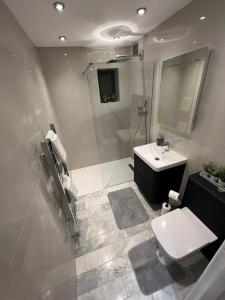 a bathroom with a white toilet and a sink at Holiday Home, Sleep 10 in London in South Norwood