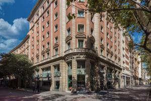 a large red brick building on a city street at Le Meridien Barcelona in Barcelona