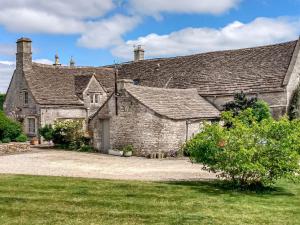 ein altes Steinhaus mit einem Rasenhof in der Unterkunft The Barn At Daubeneys in Colerne