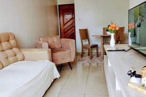 un salon avec une télévision, un canapé et des chaises dans l'établissement Sinta-se em casa! Lindo Ap para você e sua família, à Manaus