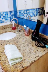 a bathroom counter with a sink and a mirror at Sinta-se em casa! Lindo Ap para você e sua família in Manaus
