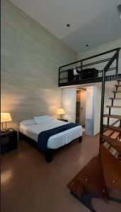 a bedroom with a bed and a spiral staircase at Giakor Suites - Gran Jardín in León