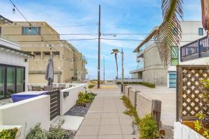 a sidewalk in front of a building with a fence at Oceanbreeze - newly remodeled delightful oasis in the heart of Mission Beach, sleeps 6 in San Diego