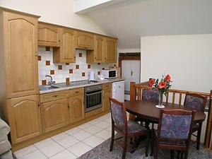 une cuisine avec une table et des chaises et une cuisine avec un évier dans l'établissement Gallaber Cottage, à Burton in Lonsdale