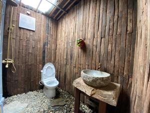 Ba Bể Hada Homestay في Ba Be18: حمام خشبي مع مرحاض ومغسلة