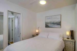 a bedroom with a white bed and two lamps at Oceanbreeze - newly remodeled delightful oasis in the heart of Mission Beach, sleeps 6 in San Diego