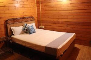 a bedroom with a bed in a wooden cabin at Coorg Northbreeze Wooden Stay in Madikeri
