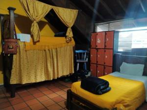 1 Schlafzimmer mit 2 Betten und gelber Bettwäsche in der Unterkunft 82Hostel in Bogotá