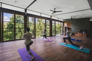 a group of people doing yoga in a room at Luwak Ubud Villa in Ubud