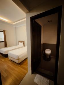 Habitación de hotel con 2 camas y aseo en Mess MT Haryono en Sampit