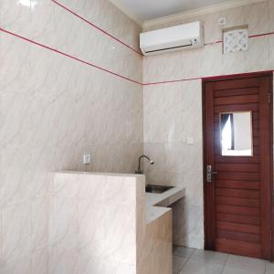 łazienka z umywalką i drzwiami w obiekcie Santhi Graha by NauliTabitha w mieście Legian