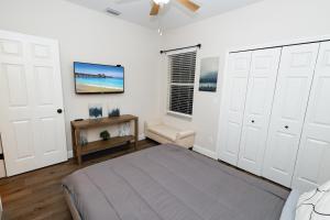 a bedroom with a bed and a tv on the wall at Stylish 2BR unit w/ hot tub 5 mins from the beach! in Bonita Springs